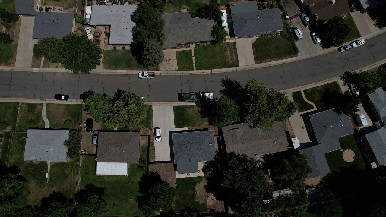 Suburban neighborhood with utility meters and solar panels illustrating rising household energy costs
