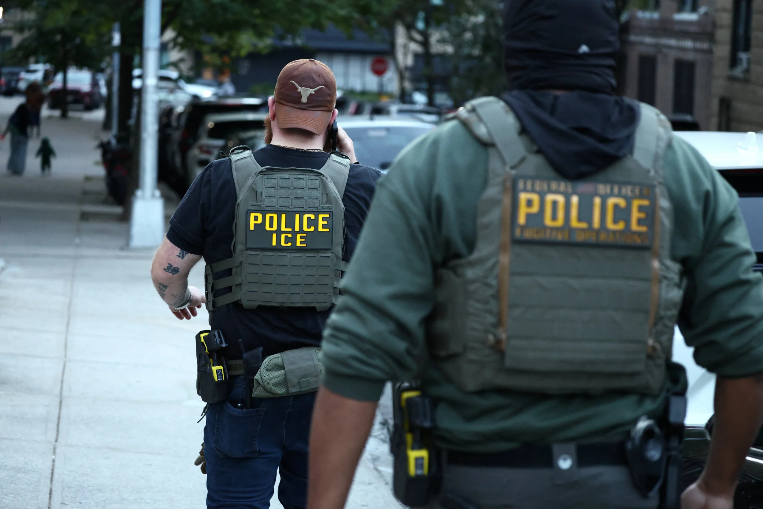 Police cruiser with federal immigration badge on a city street at dusk